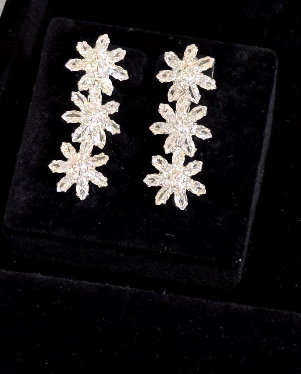 Matching silver floral crystal drop earrings displayed on black velvet