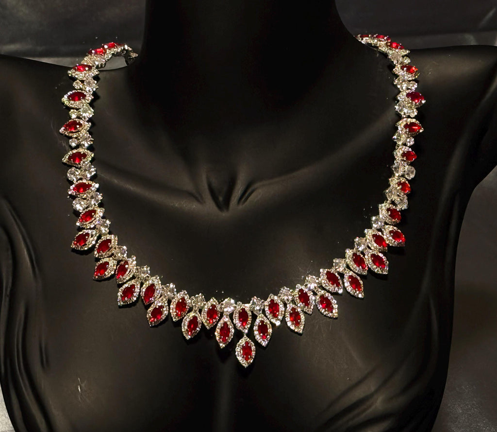 Red zircon statement necklace on a black bust, showing its graduated arrangement of oval stones and clear halo borders.