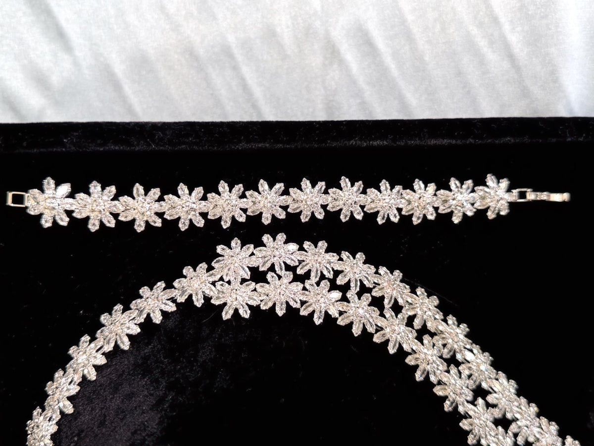 Close-up of silver crystal flower details on the bridal necklace and matching bracelet
