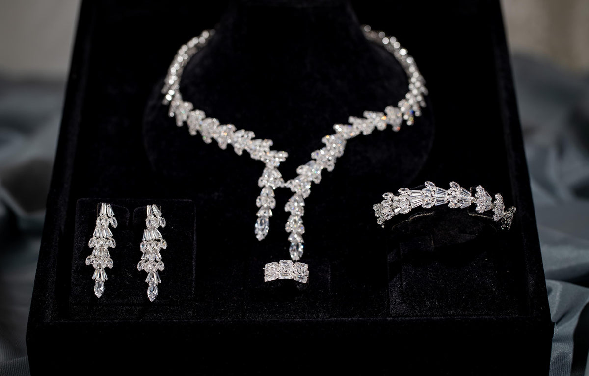 Baguette zircon double drop necklace, long earrings, bracelet and ring arranged together in a black presentation box.