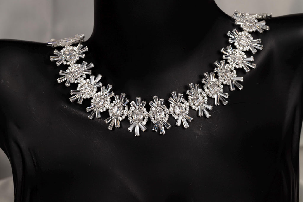 Close-up of a silver statement necklace with round and baguette-cut cubic zirconia stones
