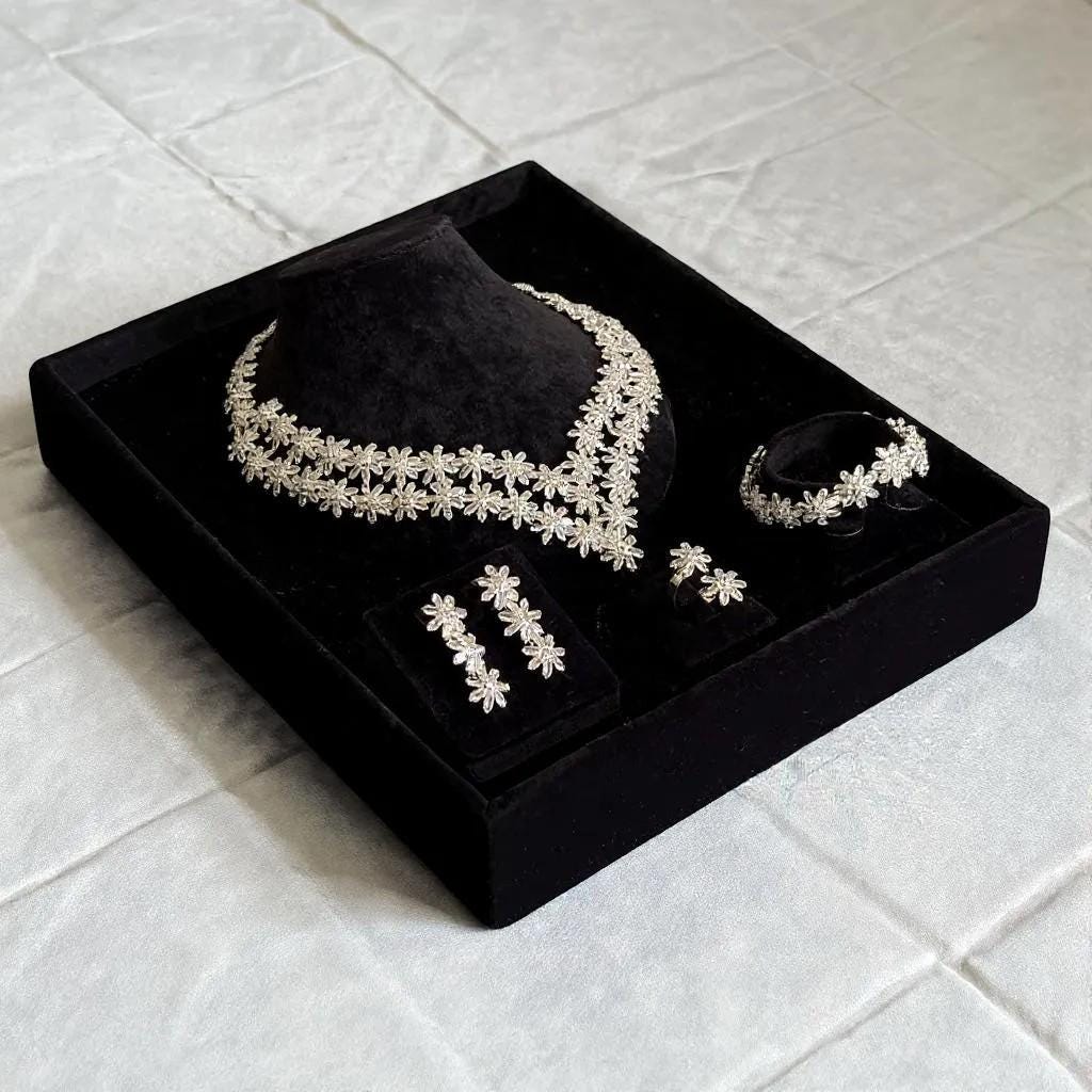 Four-piece silver floral crystal bridal jewelry set presented in a black gift box