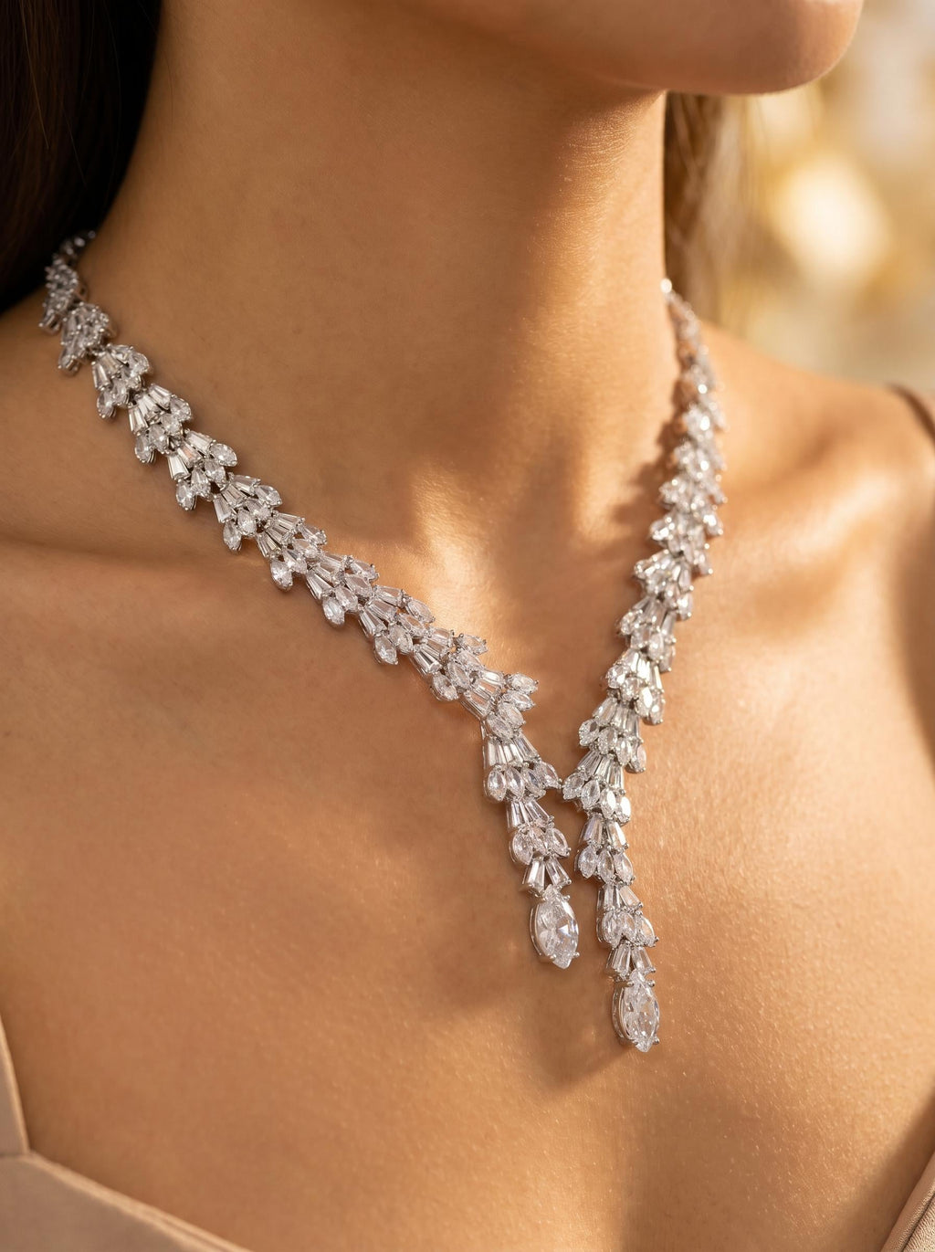 Close-up of a baguette zircon bridal necklace worn at the neckline, showing its fan-shaped details and twin pendant drops.
