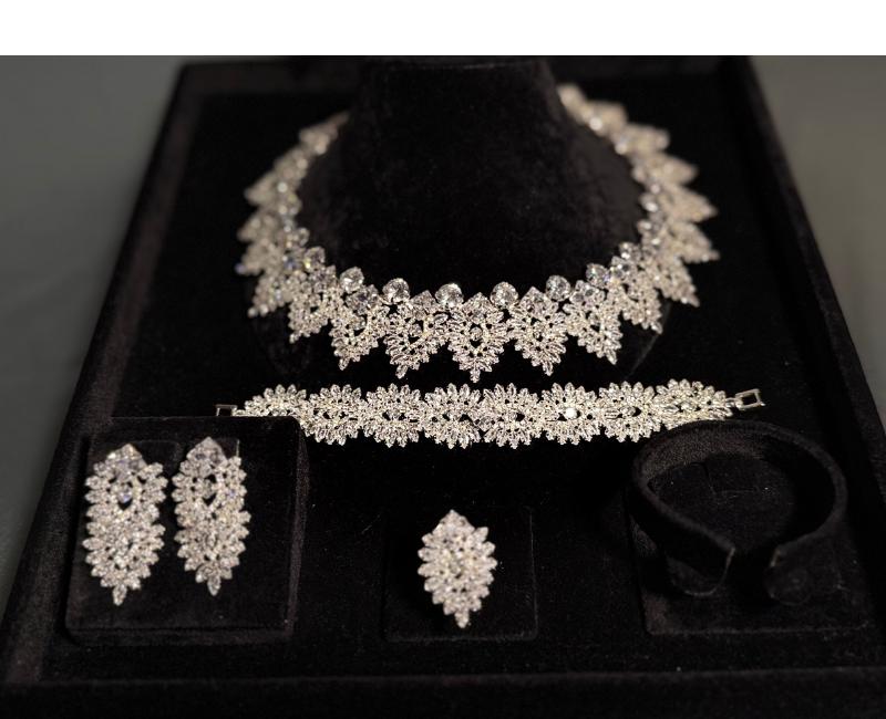 Four-piece silver-tone bridal jewelry set arranged in a black velvet display box with matching ornate crystal motifs
