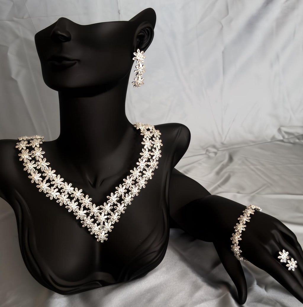 Silver floral crystal necklace and matching bracelet displayed on a black mannequin