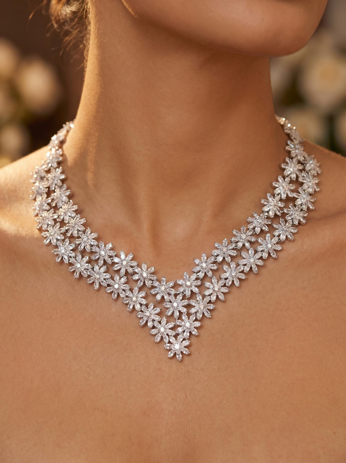 Close-up of double-layer V-shaped floral crystal necklace worn with matching bridal earrings