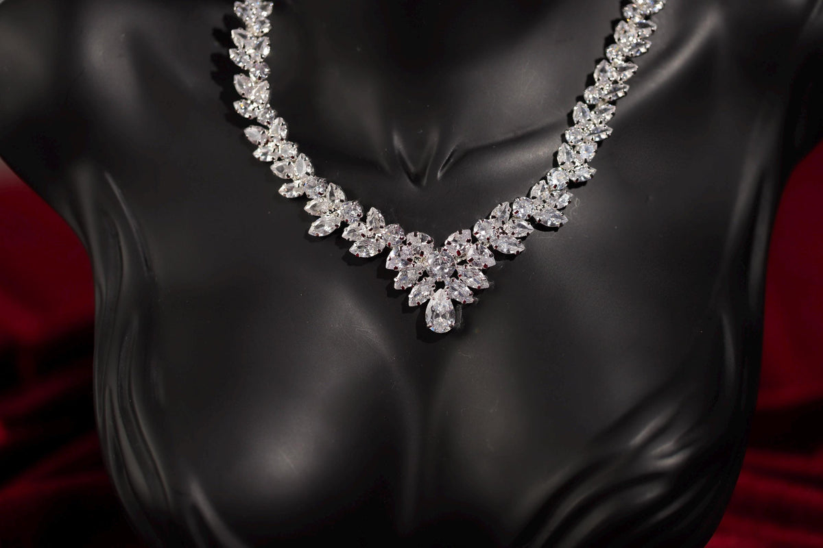 Silver marquise crystal statement necklace shown on a black mannequin bust.