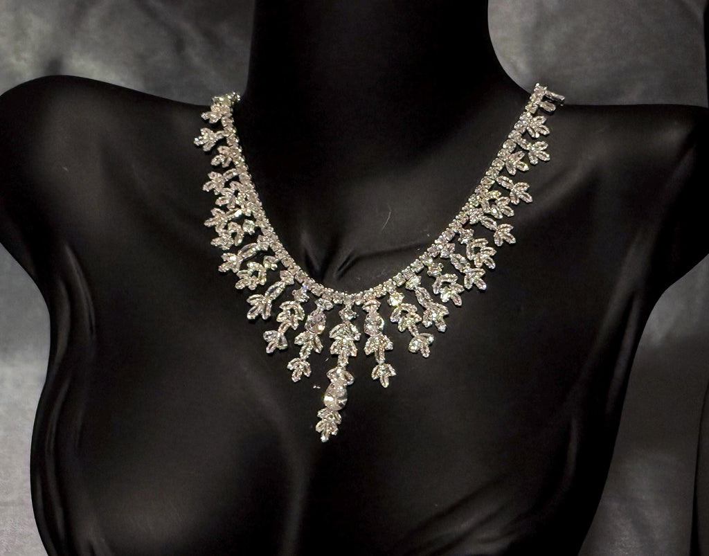 Close-up of a cascading bridal necklace with delicate leaf and flower motifs, pear-shaped stones and an elongated center.