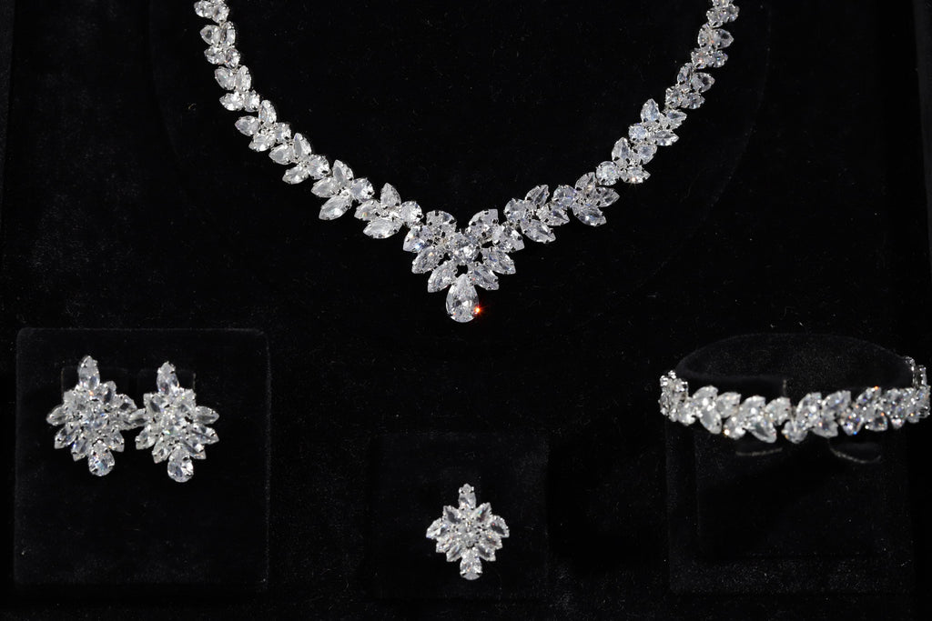 Silver marquise crystal necklace, earrings, bracelet and adjustable ring displayed on black velvet.