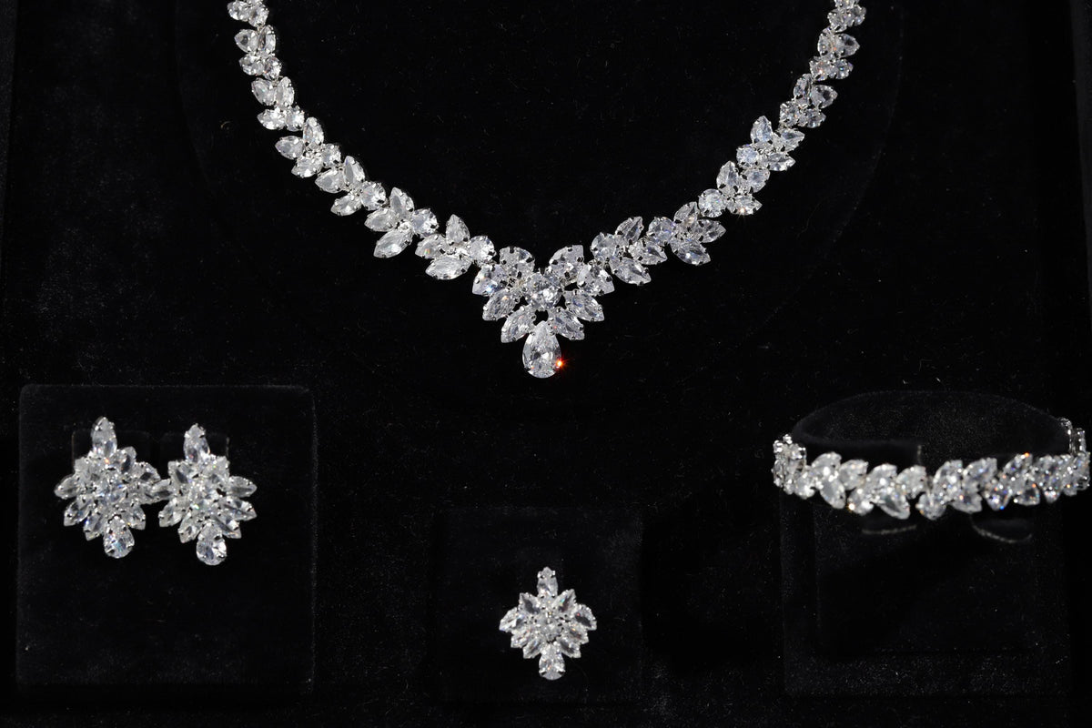 Silver marquise crystal necklace, earrings, bracelet and adjustable ring displayed on black velvet.