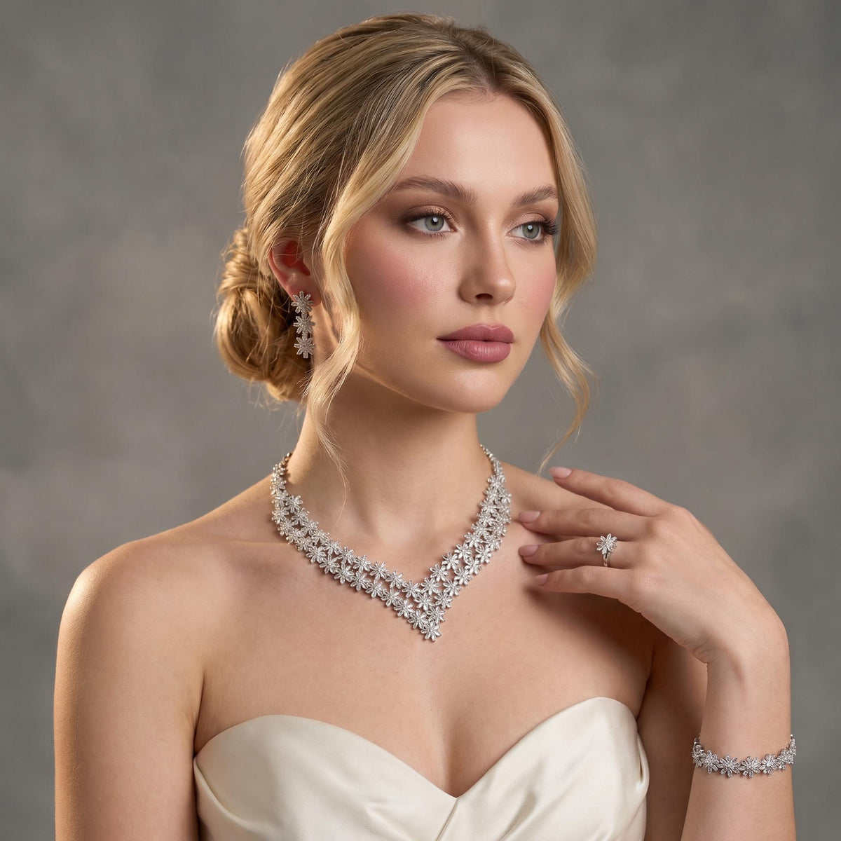 Bride wearing a silver floral crystal jewelry set with double-layer V necklace, earrings, bracelet and ring
