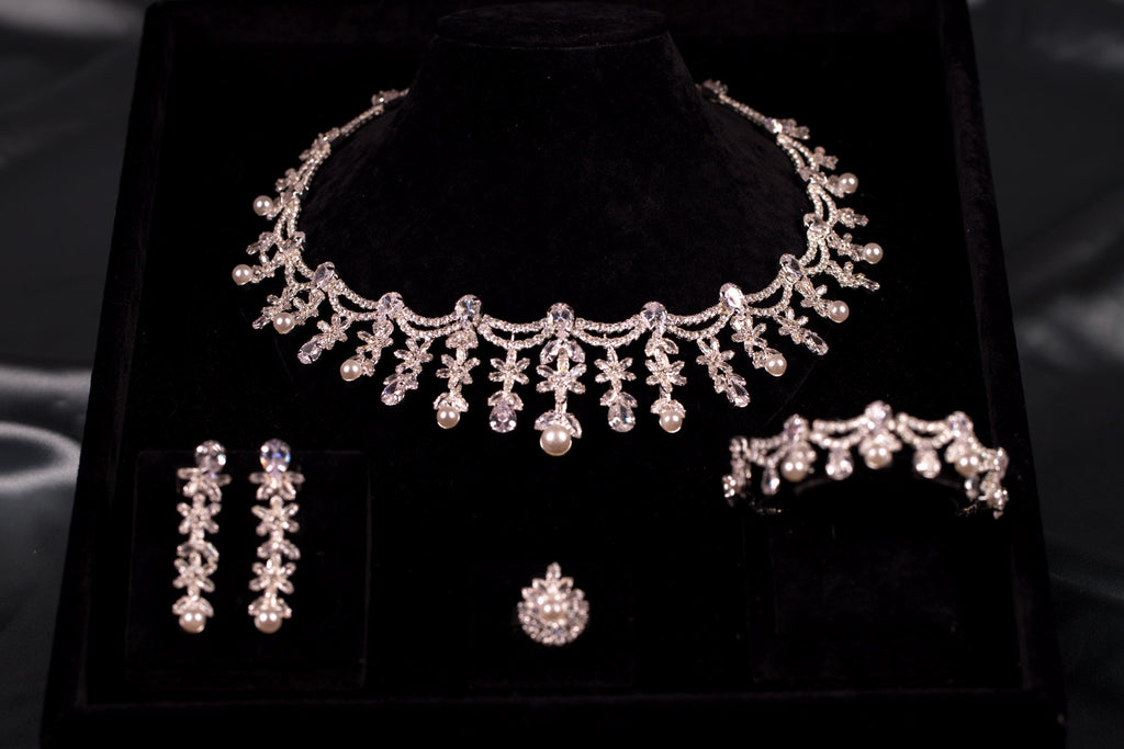 Four-piece silver bridal jewelry set with floral cubic zirconia stones and faux pearl drops