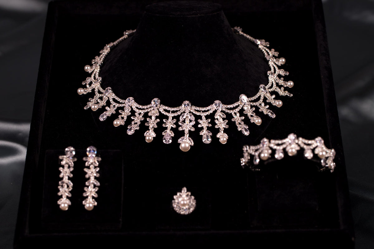 Four-piece silver bridal jewelry set with floral cubic zirconia stones and faux pearl drops