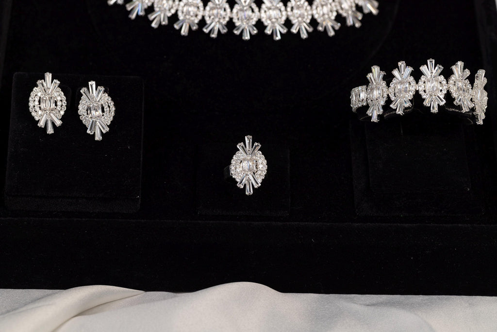 Close-up of matching earrings, bracelet and ring from a silver crystal jewelry set