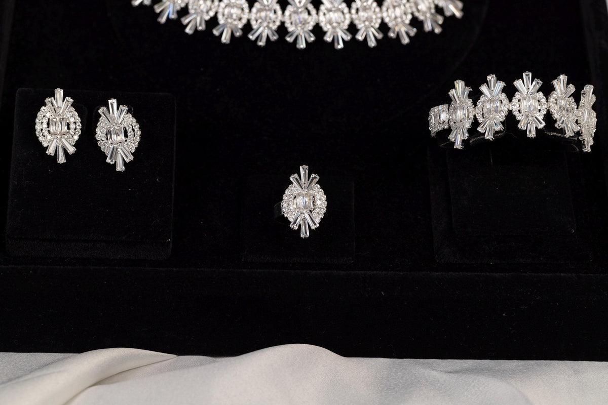 Close-up of matching earrings, bracelet and ring from a silver crystal jewelry set
