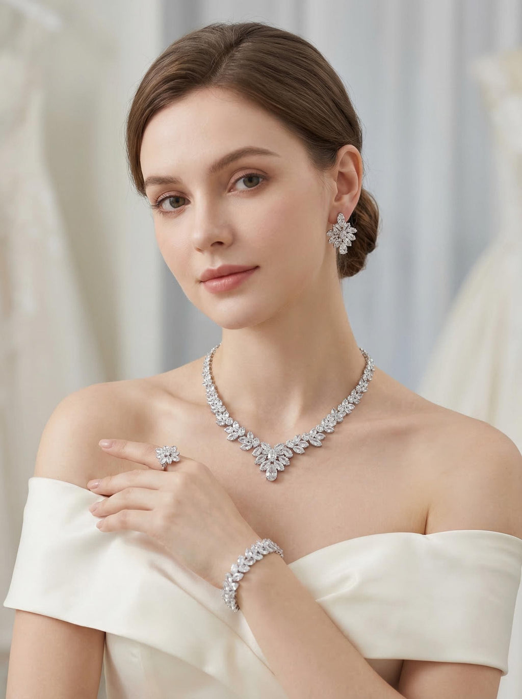 Bride wearing a silver marquise crystal necklace, earrings, bracelet and ring with an off-shoulder gown.