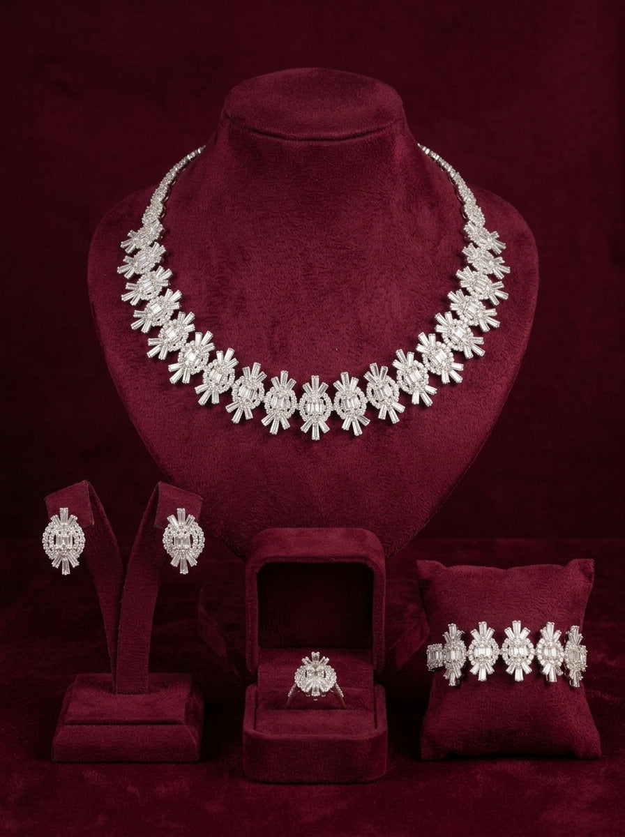 Silver crystal statement jewelry set with necklace, earrings, bracelet and ring displayed on burgundy velvet