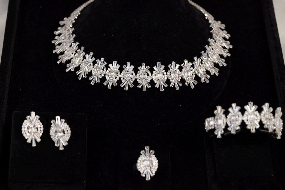 Silver statement jewelry set with floral-inspired crystal necklace, earrings, bracelet and ring