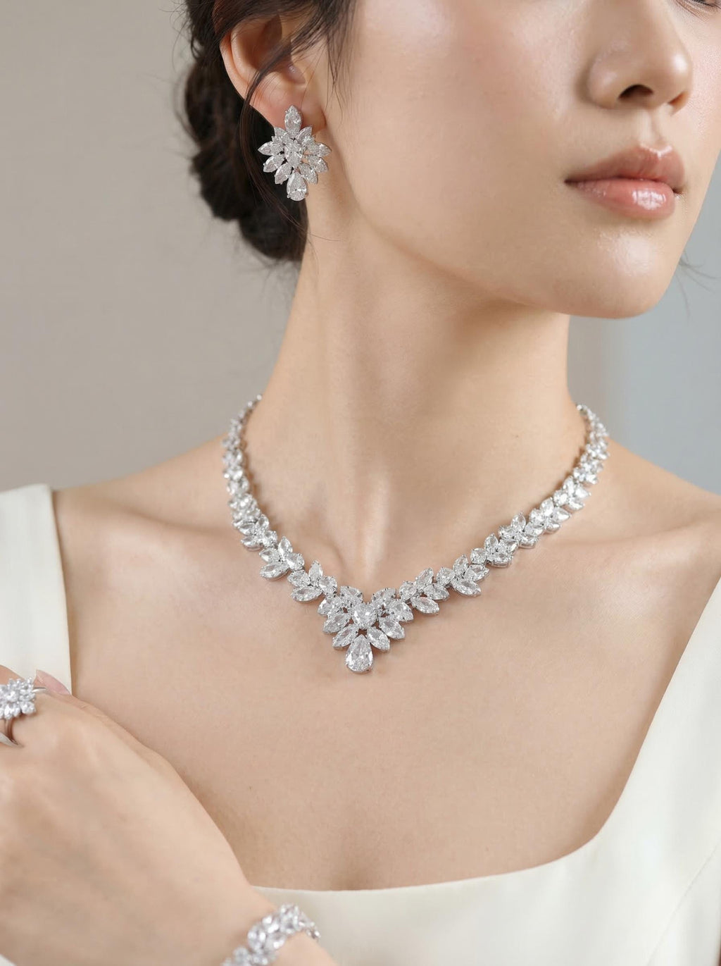Close-up of a woman wearing the silver marquise crystal necklace and matching earrings with a white dress.