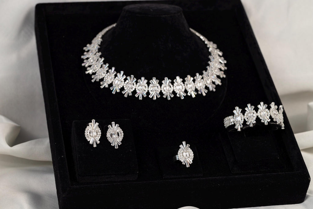 Silver crystal necklace, earrings and ring displayed inside a black jewelry box