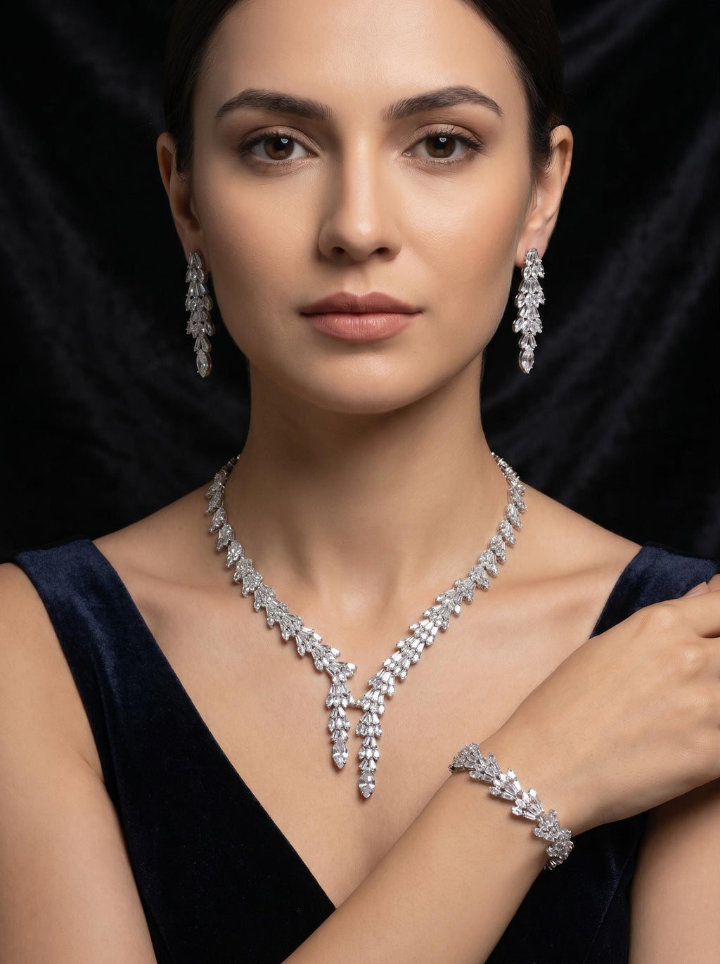 Model in a black dress wearing a baguette zircon double drop necklace with coordinating earrings and bracelet.