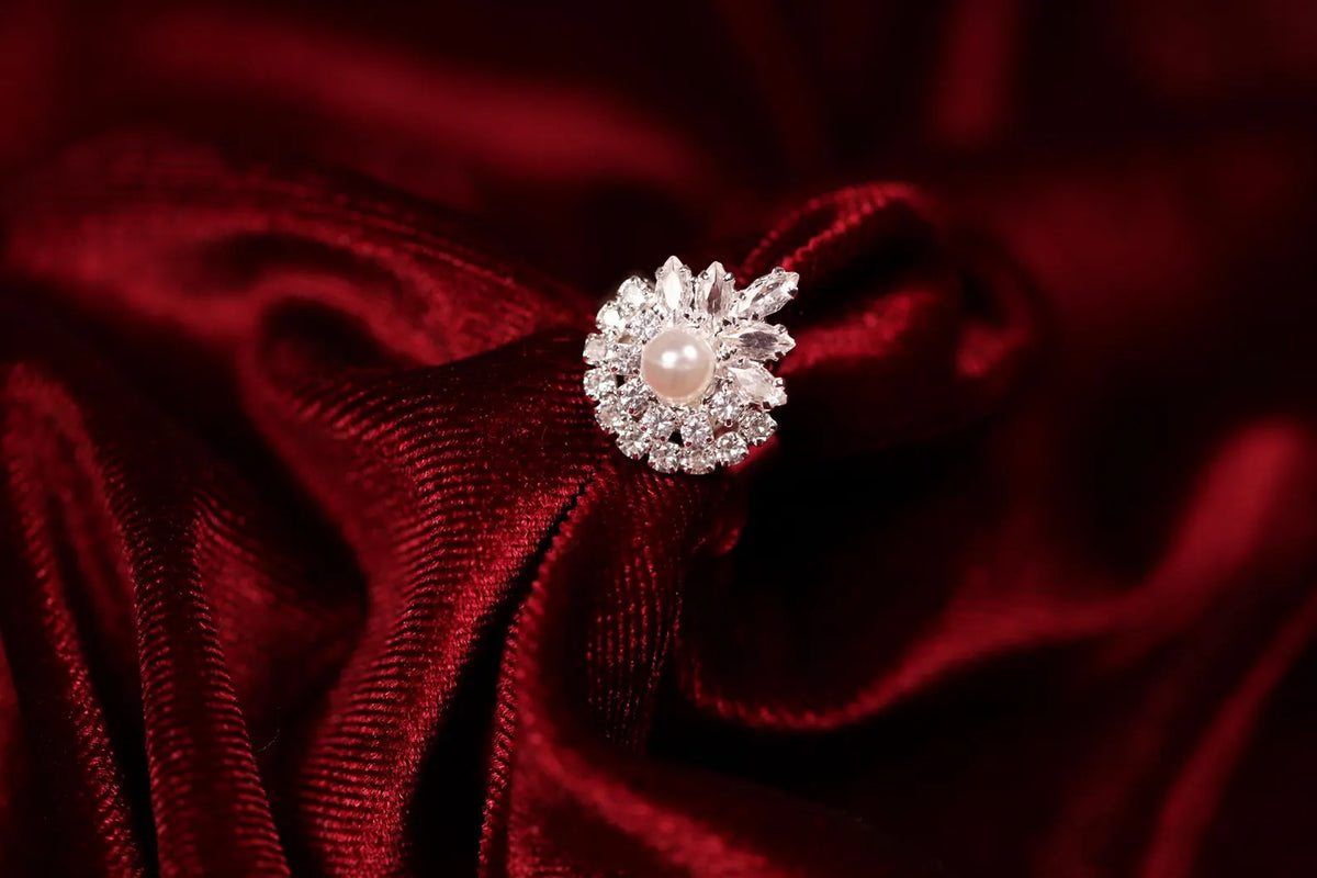 Adjustable silver floral cubic zirconia statement ring displayed on red satin