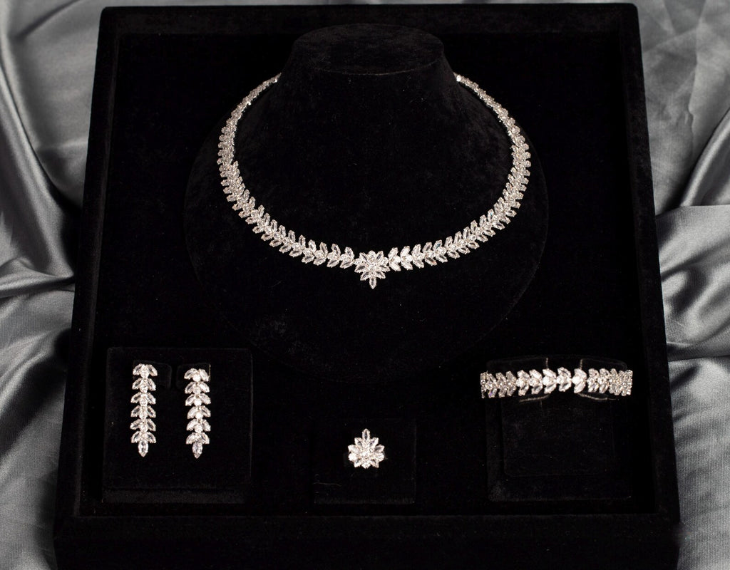 Front view of a leaf and flower zircon jewelry set in a black velvet box framed by silver-gray satin.