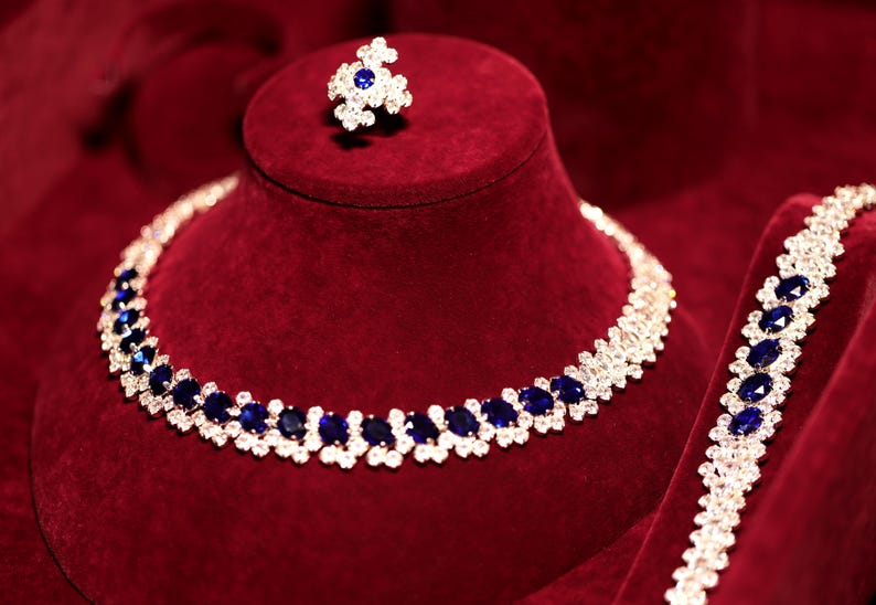Royal blue crystal necklace and matching jewelry displayed on burgundy velvet