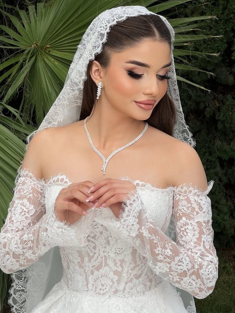 Bride wearing a silver crystal teardrop necklace with matching bridal earrings and bracelet