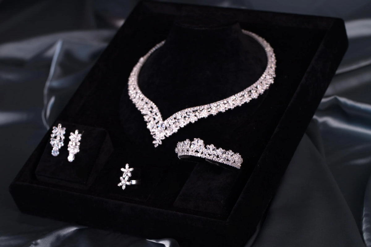 Angled view of a silver-tone floral bridal jewelry set in a black velvet presentation box surrounded by gray satin.