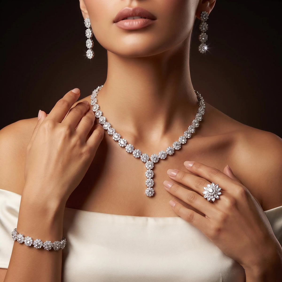 Model wearing a zircon flower Y necklace with matching earrings, bracelet and a larger floral ring against an ivory gown.