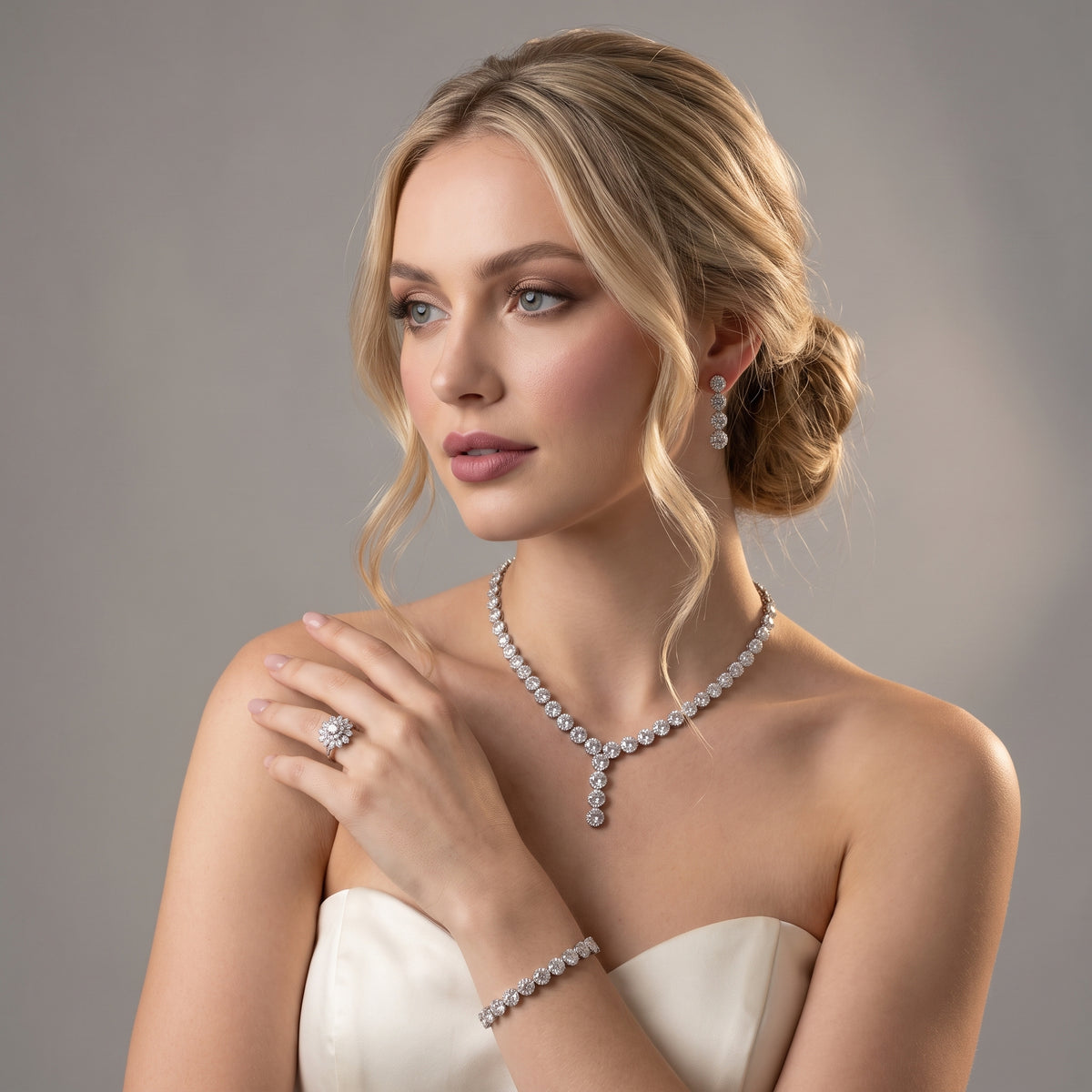 Bride wearing a silver-tone mini flower jewelry set with a Y-shaped necklace, floral drop earrings, bracelet and ring.
