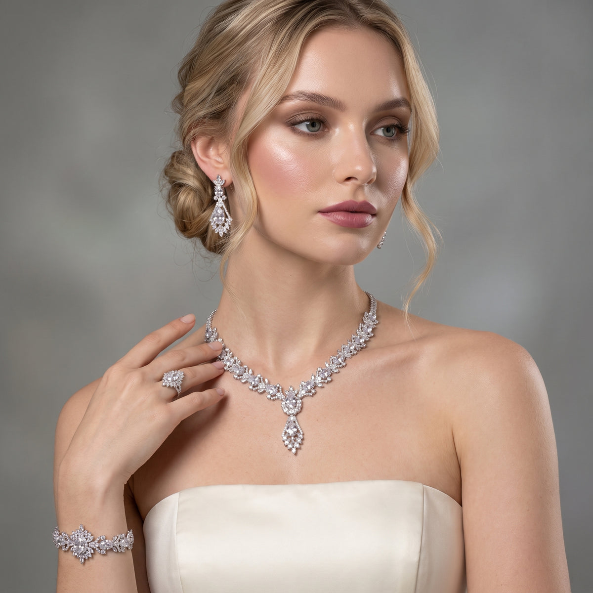Model wearing a silver-tone teardrop jewelry set with a statement necklace, drop earrings, bracelet and ring
