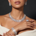 Model wearing a silver crystal necklace, matching earrings, bracelet and statement ring