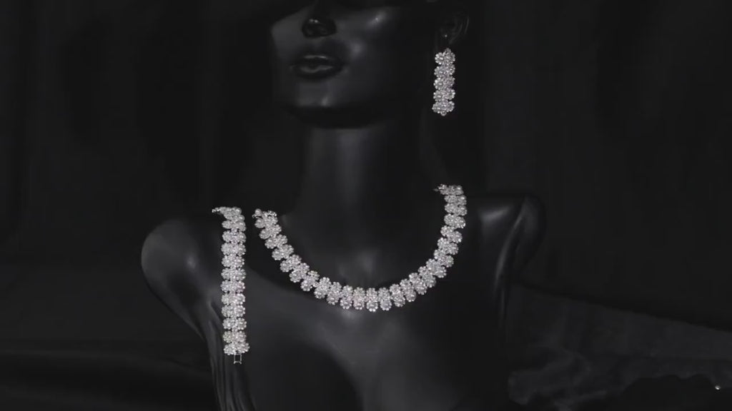 Floral faux pearl bridal necklace displayed on a black mannequin bust with coordinating jewelry.