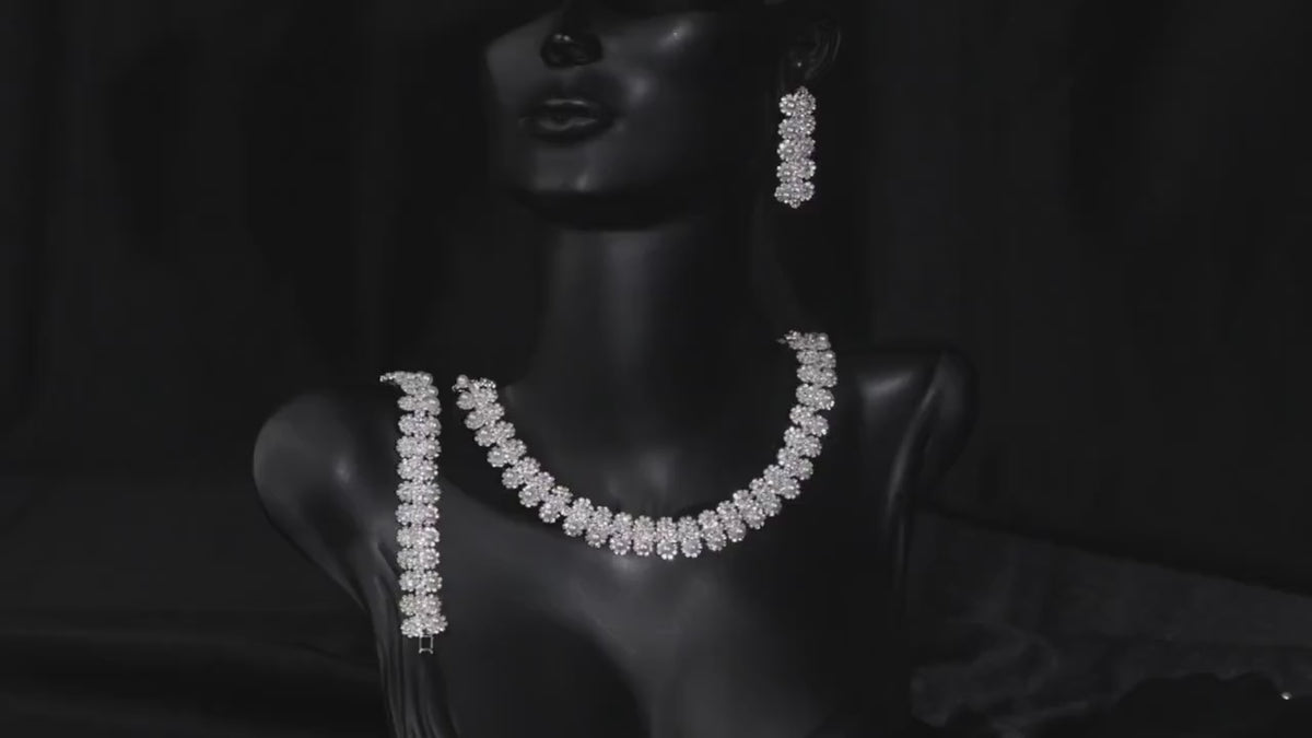 Floral faux pearl bridal necklace displayed on a black mannequin bust with coordinating jewelry.
