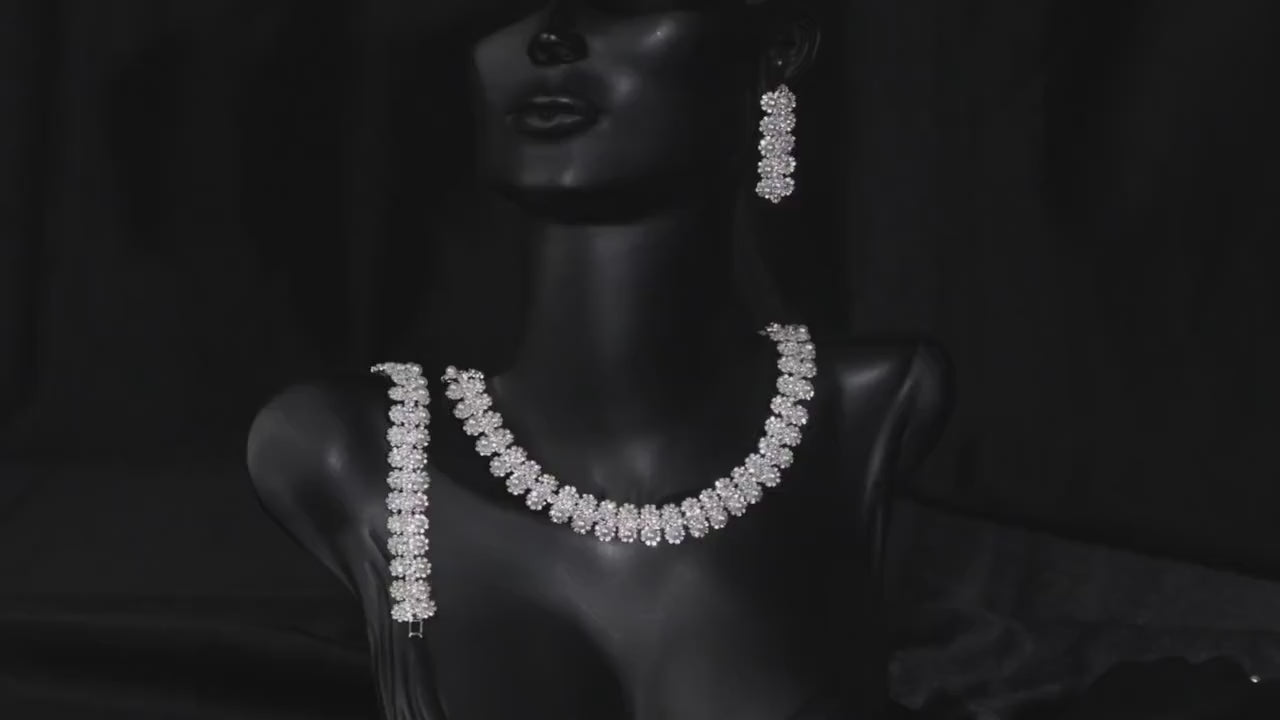 Floral faux pearl bridal necklace displayed on a black mannequin bust with coordinating jewelry.