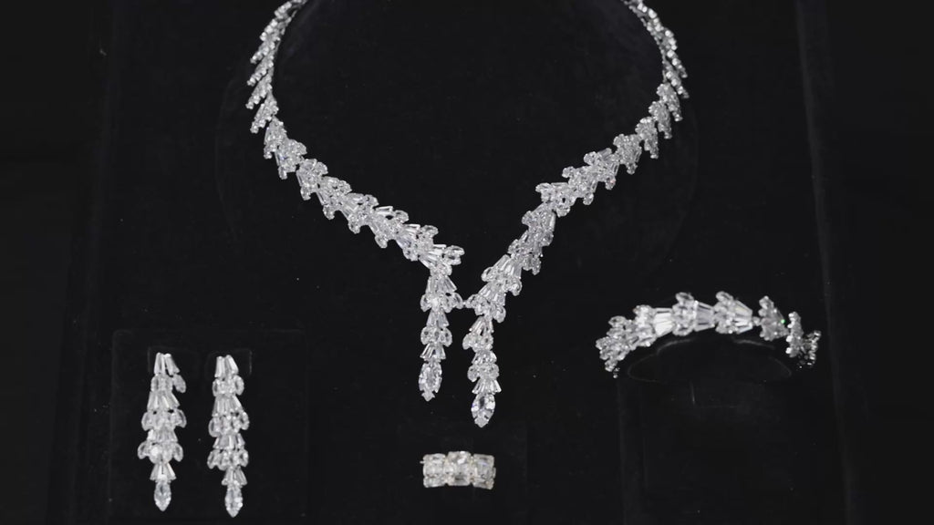 Baguette zircon bridal jewelry set displayed on black velvet, featuring a double drop necklace, long earrings, bracelet and ring.