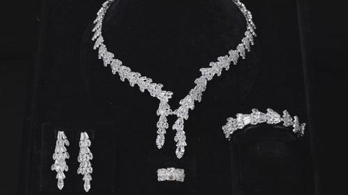 Baguette zircon bridal jewelry set displayed on black velvet, featuring a double drop necklace, long earrings, bracelet and ring.